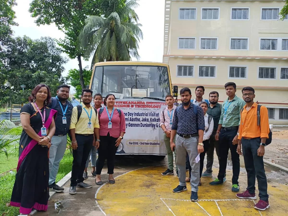 Civil Engineering third-year students and faculty of SVIST posing beside a bus with a banner for their one-day industrial visit to a Gannon Dunkerley & Co. construction site at Joka, Kolkata